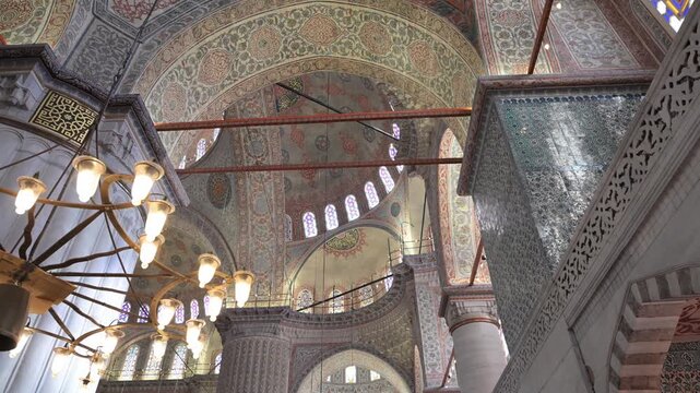 A slow pan left reveals the massive "elephant foot" columns and grand arches of the Blue Mosque in Istanbul, Turkey. A stunning look at Ottoman architectural mastery and scale.