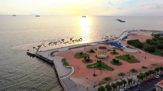 romantic sunset in Livorno Italy, Gazebo Terrazza Mascagni and park on the Ligurian Sea, soft warm Tuscan sun glow at sunset