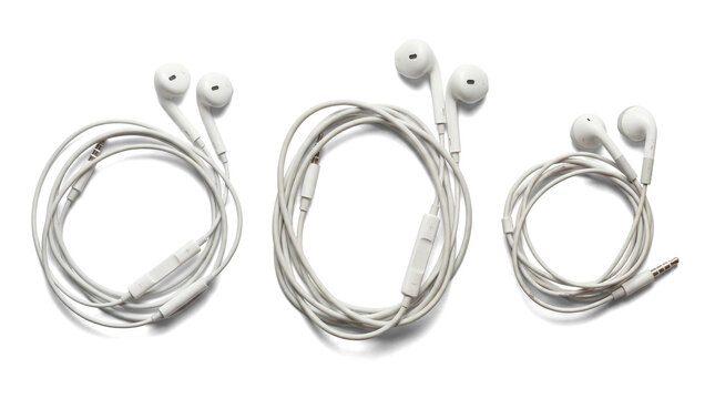 three pairs of white earbuds, each coiled and presented with their audio connector, isolated on a pure transparent background for clear focus.