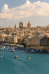 Fototapeta premium Puerto de Birgu (Vittoriosa) en Malta con barcos deportivos y arquitectura histórica al atardecer. Ambiente veraniego mediterráneo.