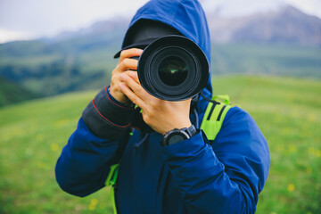 Fototapeta premium Photographer taking photo on grassland mountain top