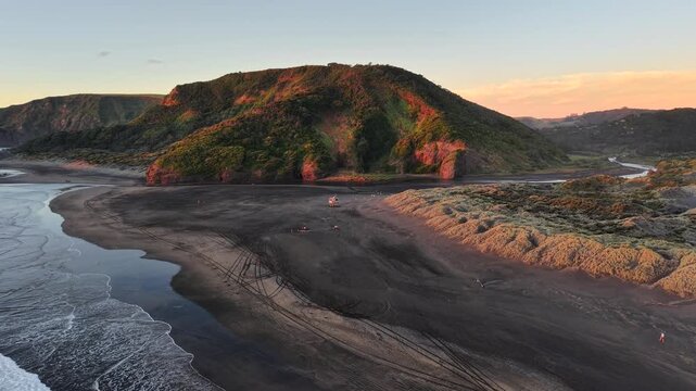 Aerial View of Black Sand Beach and Coastal Hills at Sunset in New Zealand