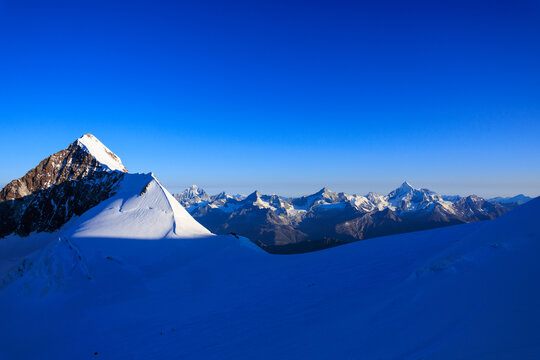 Mountain glacier panorama with summits Lyskamm, Dent Blanche, Zinalrothorn and Weisshorn (left to right) seen from Monte Rosa massif in Pennine Alps, Italy