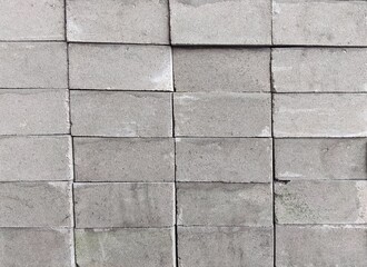 Fototapeta premium ​Neat stack of gray concrete blocks background texture
