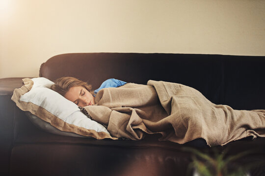 Couch, sleep and woman with blanket in home for relax, peace or calm on weekend break in living room. Exhausted, power nap and tired person on sofa in house with fatigue, rest and dream for wellness