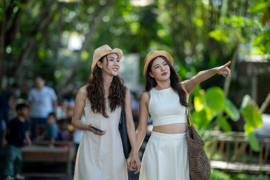 Young asian women friends traveling, exploring and pointing