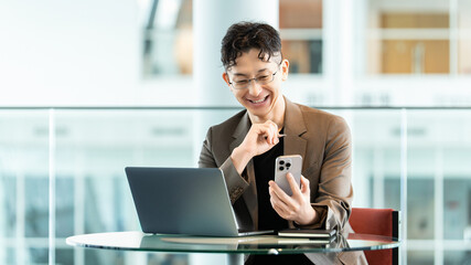 スマートフォンとノートパソコンを使う男性ビジネスパーソン, Businessman using a smartphone and laptop © Trickster*