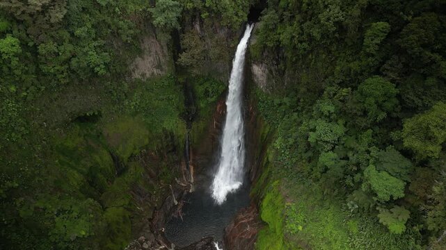Aerial pull away from beautiful Catarata del Toro waterfall in Bajos Del Toro Costa Rica in lush rain forest
