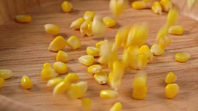 Sprinkle corn kernels into the wooden cup.