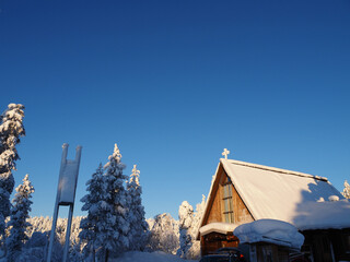 Snow Covered Wooden Church in Saariselka Finland Surrounded by Winter Forest