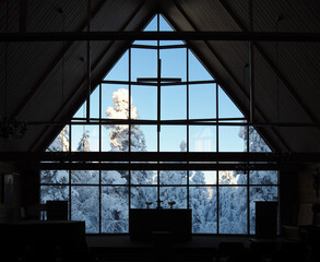Scandinavian Wooden Church with Cross Silhouette and Snowy Landscape Outside