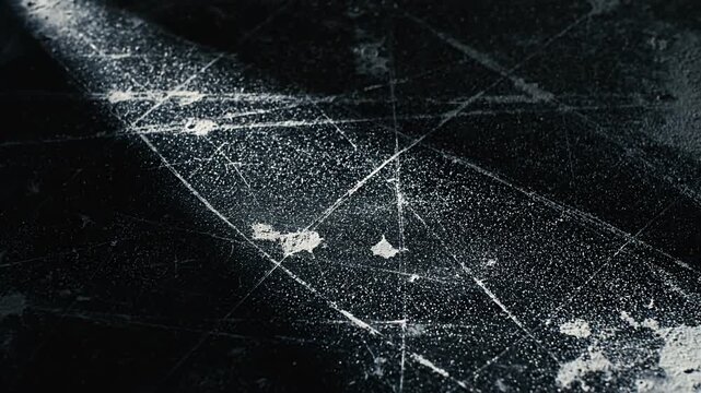 Dark textured surface with numerous white scratches and grunge marks.