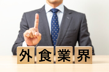 Obraz premium 「外食業界」と書かれたブロックとビジネスマン