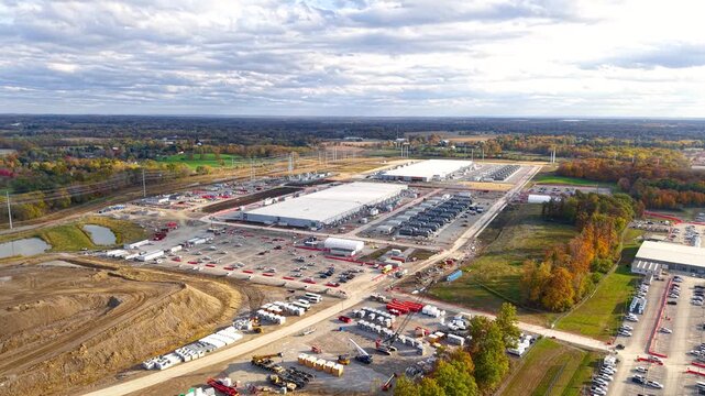 Wide aerial shot revealing a massive industrial complex and data center under construction