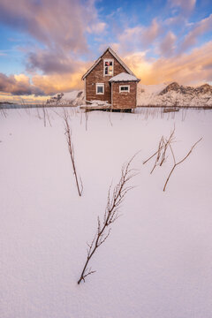 casa vieja de madera noruega en paisaje artico con nieve