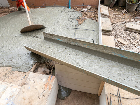Fresh concrete pouring from the chute at the construction site.