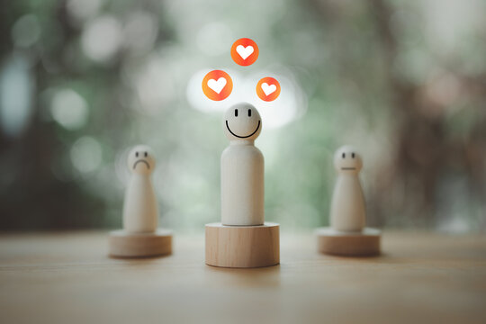 Happy wooden peg doll with heart above head standing out from the with diverse emotions. Leadership, positive attitude, and customer satisfaction, represented by wood figures in a minimalist setting