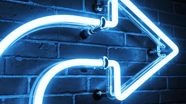 Bright blue neon arrow sign glowing on a dark brick wall background.