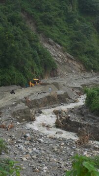 JCB backhoe loader clearing debris after cloudburst in Rajpur Dehradun