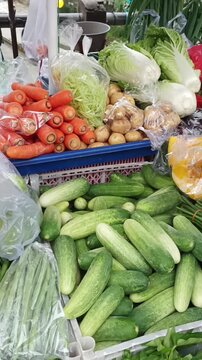 Customer buying fresh chayote from a street vendor at a traditional market. Hands exchanging vegetables and money.
