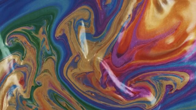 Vibrant llic paints swirl and blend creating an abstract fluid art background.