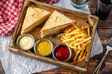 Club sandwich platter with fries and dipping sauces
