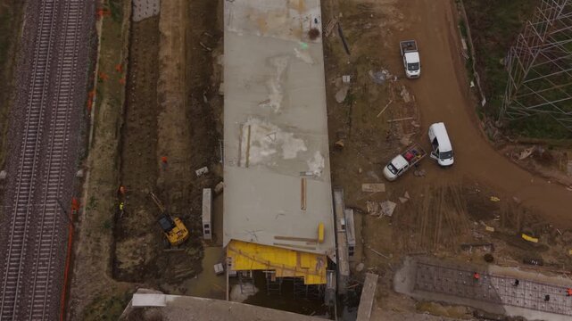Drone footage shows large machinery preparing a railway corridor, highlighting transportation infrastructure growth and modern construction activities in Italy.