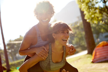 Piggyback, love and smile with lesbian couple in park for commitment, bonding and summer holiday. Happy, lgbt connection and date with women in nature for romantic vacation, support and care together
