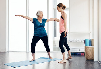 Fototapeta premium Happy, instructor and stretching with old woman for yoga guidance, fitness support and zen. Smile, personal trainer or senior person with warrior pose for inner peace, holistic coaching and self care