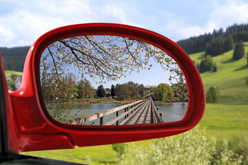 Obraz premium Landscape reflected in the rear view mirror of a red car - spring series