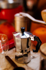 Ingredients for making coffee. Moka pot, bean spray, coffee grinder with coffee beans standing on the kitchen table.