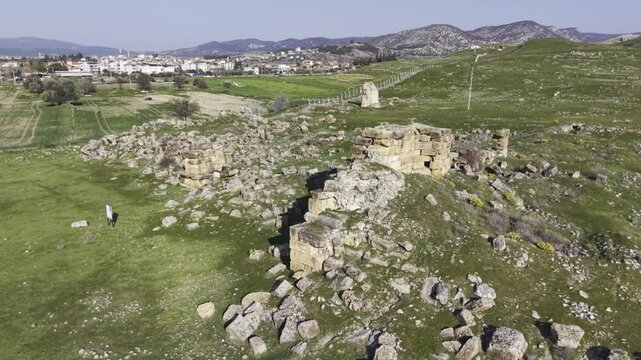 Cinematic aerial drone video of Tripolis Antik Kenti near Buldan in Denizli, Turkey, featuring Roman ruins, columns, stone structures, and panoramic scenic landscape from above.
