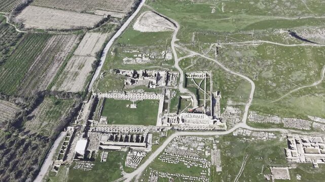 Cinematic aerial drone video of Tripolis Antik Kenti near Buldan in Denizli, Turkey, featuring Roman ruins, columns, stone structures, and panoramic scenic landscape from above.
