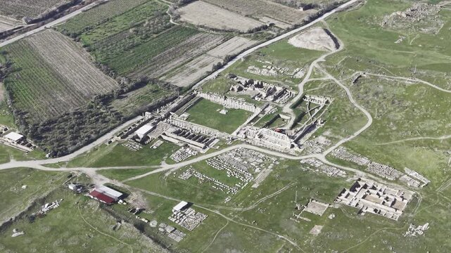 Cinematic aerial drone video of Tripolis Antik Kenti near Buldan in Denizli, Turkey, featuring Roman ruins, columns, stone structures, and panoramic scenic landscape from above.