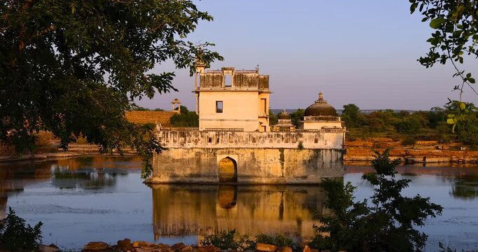 Historic Padmini Palace reflecting on the water at sunset in Chittorgarh Fort