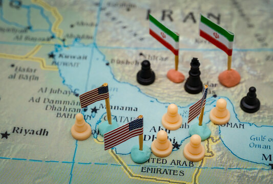 Conceptual representation of the geopolitical conflict between Iran and the USA in the Strait of Hormuz, with chess pieces and national flags symbolizing military strategy over oil control