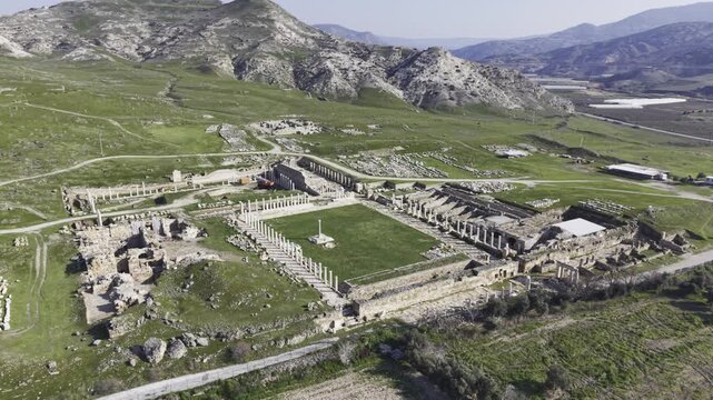 Cinematic aerial drone video of Tripolis Antik Kenti near Buldan in Denizli, Turkey, featuring Roman ruins, columns, stone structures, and panoramic scenic landscape from above.