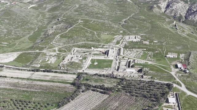 Cinematic aerial drone video of Tripolis Antik Kenti near Buldan in Denizli, Turkey, featuring Roman ruins, columns, stone structures, and panoramic scenic landscape from above.