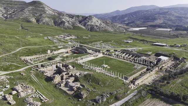 Cinematic aerial drone video of Tripolis Antik Kenti near Buldan in Denizli, Turkey, featuring Roman ruins, columns, stone structures, and panoramic scenic landscape from above.
