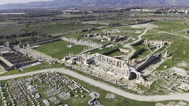 Cinematic aerial drone video of Tripolis Antik Kenti near Buldan in Denizli, Turkey, featuring Roman ruins, columns, stone structures, and panoramic scenic landscape from above.