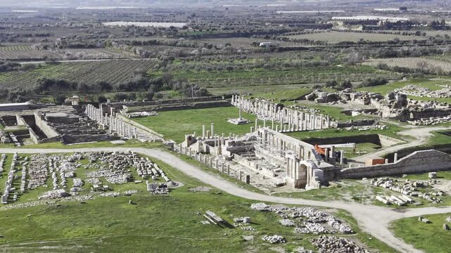 Cinematic aerial drone video of Tripolis Antik Kenti near Buldan in Denizli, Turkey, featuring Roman ruins, columns, stone structures, and panoramic scenic landscape from above.