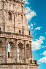 Obraz premium Famous Roman Colosseum, an ancient amphitheater and UNESCO world heritage site, glowing under the warm sunlight, a testament to imperial Roman architecture and history in Italy