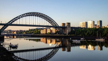 Obraz premium Scenic morning view of an arched steel bridge reflecting in calm water, urban background
