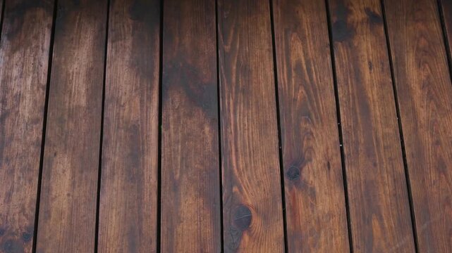 Dark brown wooden planks background texture with visible grain and knots, outdoor surface detail