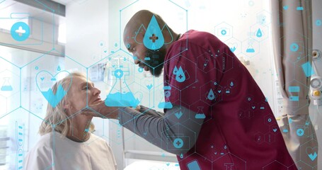 Examining clinician in burgundy scrubs leaning over patient in light gown at clinic exam bed, AR