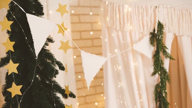 Green fir tree with golden star garland and white pennant banner decorations