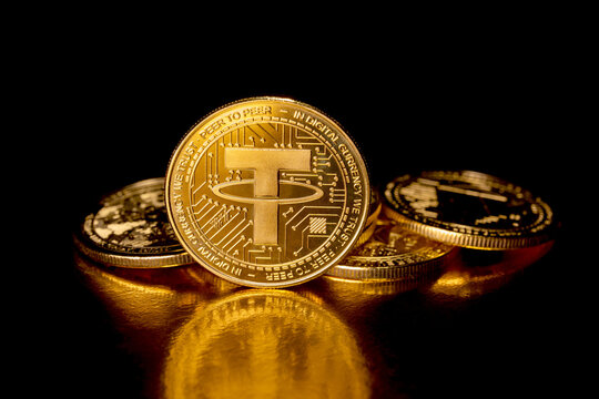 Kyiv, Ukraine - October 18, 2025. Tether USDT cryptocurrency and gold coins. Macro photography. A USDT coin isolated on a black background. Gold coins with a Tether coin in front of it. Cryptocurrency