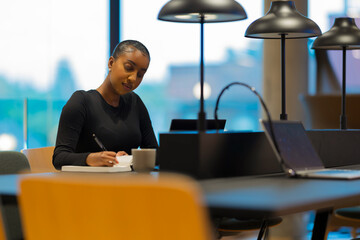 Woman writing notes in modern office