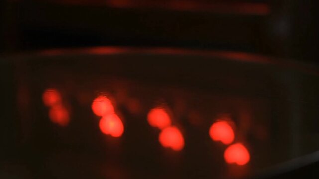 Glowing Red Embers in Dark Container.
