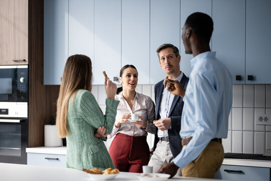 Business colleagues having coffee break in office kitchen